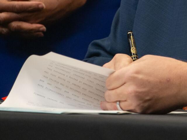 Gov. JB Pritzker signs a bill into law. (Capitol News Illinois photo by Maggie Dougherty)