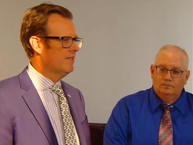 Peter Cadigan, right, listens as attorney Justin Kuehn speaks to reporters following Cadigan's sentencing.