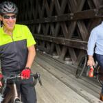 Rahm Emanuel takes a break from a bike ride through New Hampshire, Saturday, June 6, 2026. (AP Photo/Steven Sloan)