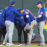 Chicago Cubs right fielder Seiya Suzuki, center front, is checked after being injured while attempting to catch a fly ball during the fourth inning of a baseball game against the San Francisco Giants, Saturday, June 13, 2026, in San Francisco, Calif. (AP Photo/Scott Marshall)