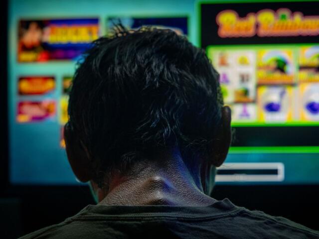 A man spends the last three dollars in his pocket playing a bar slot machine in downstate Golconda on June 4, and then leaves. (Credit: Julia Rendleman for Capitol News Illinois)