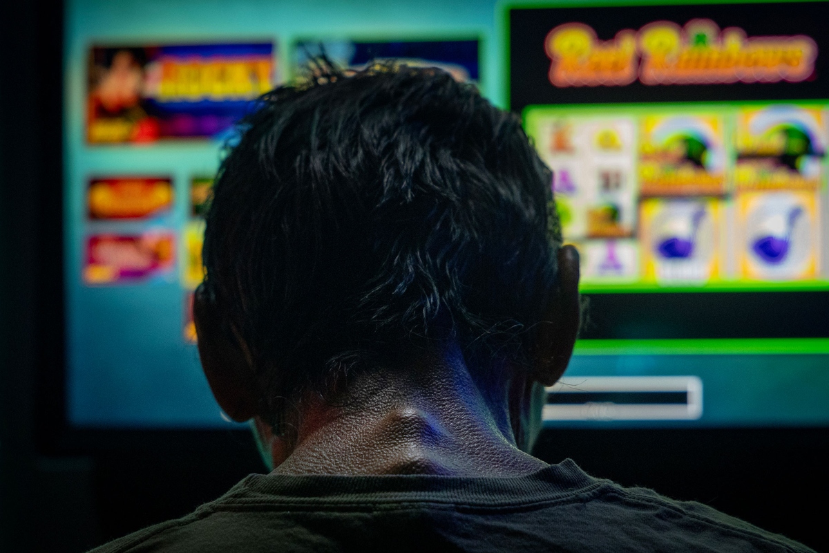A man spends the last three dollars in his pocket playing a bar slot machine in downstate Golconda on June 4, and then leaves. (Credit: Julia Rendleman for Capitol News Illinois)