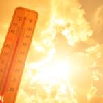 Thermometer against background hot, summer yellow sun. Hot weather and high air temperature.