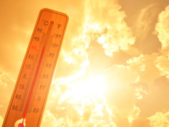 Thermometer against background hot, summer yellow sun. Hot weather and high air temperature.