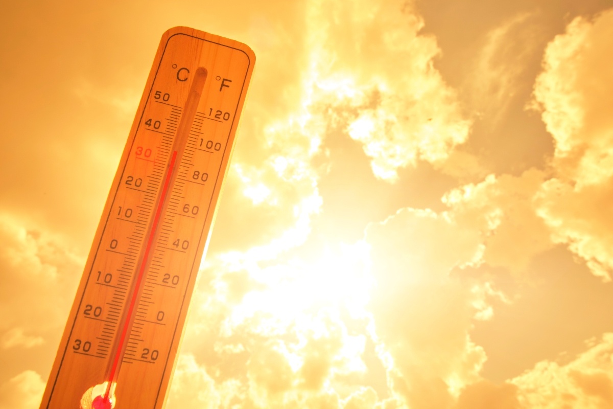 Thermometer against background hot, summer yellow sun. Hot weather and high air temperature.