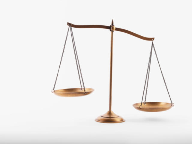Brass balance scale with two hanging pans, symbolizing justice and fairness on a white background.