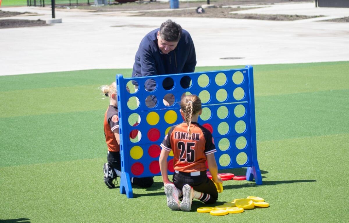 Gov. JB Pritzker plays Connect 4 with children following an event to open a new sports park in Springfield on April 28, 2026. (Capitol News Illinois photo by Jerry Nowicki)