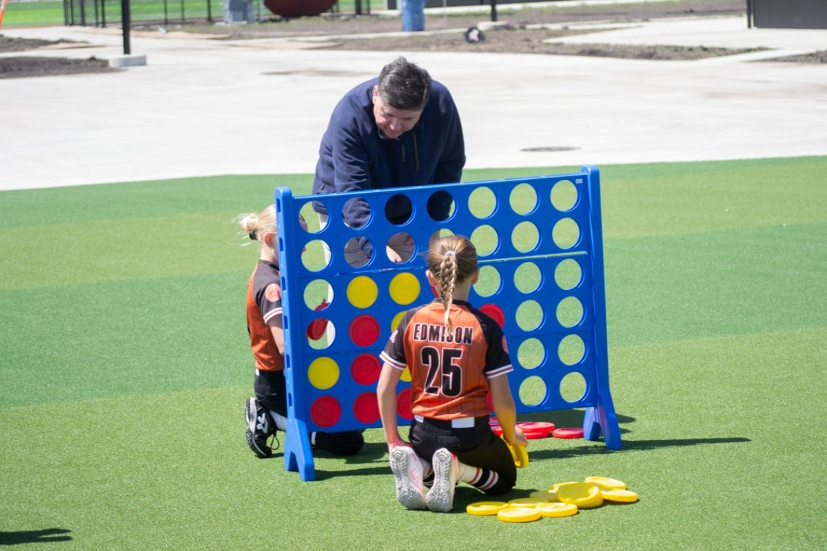 Gov. JB Pritzker plays Connect 4 with children following an event to open a new sports park in Springfield on April 28, 2026. (Capitol News Illinois photo by Jerry Nowicki)