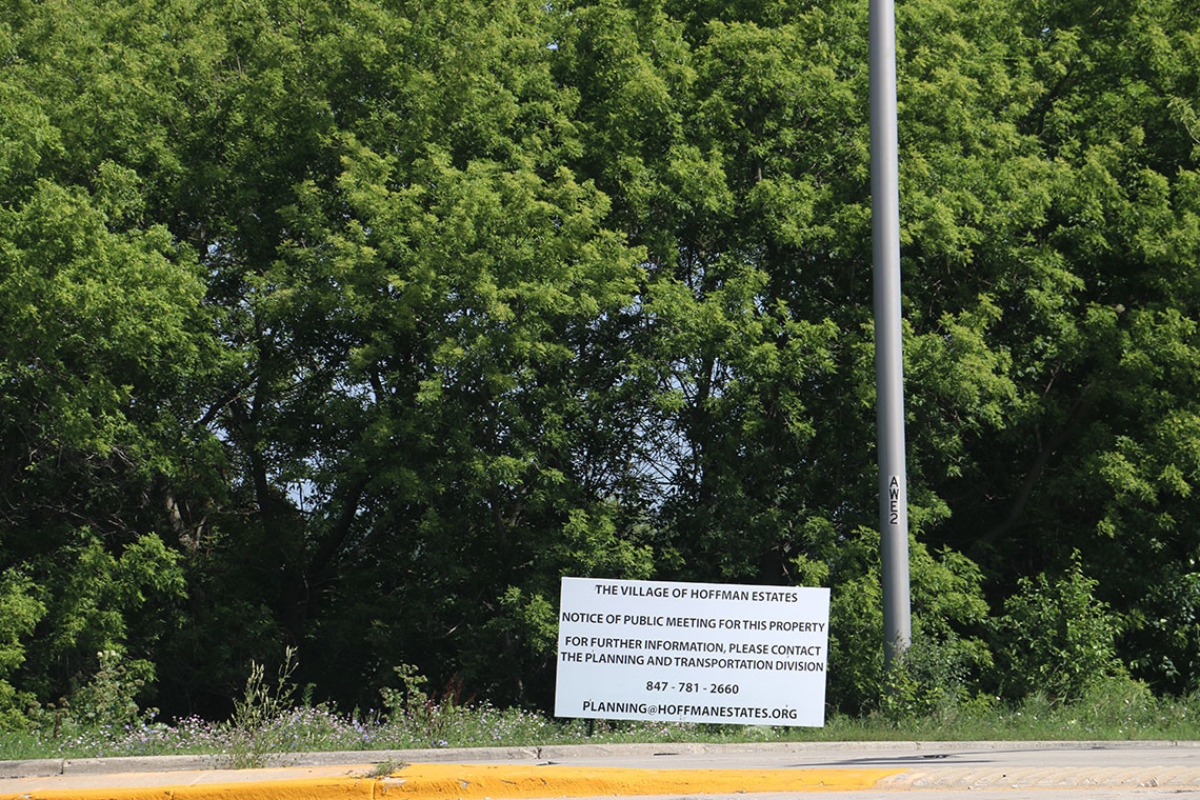 A sign provides notice for a public meeting of the Hoffman Estates Plan Commission to discuss rezoning the 186-acre property at Higgins Road and Route 59. The developer notified the village on July 1 that it would withdraw the rezoning request after community backlash. (Capitol News Illinois photo by Maggie Dougherty)