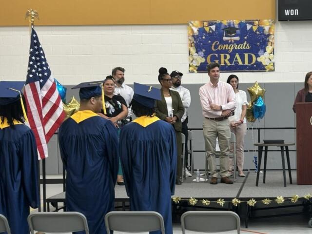 Traci Kinsley (at podium), principal of the high school at Monarch Youth Center, speaks to the graduates Monday, June 29.