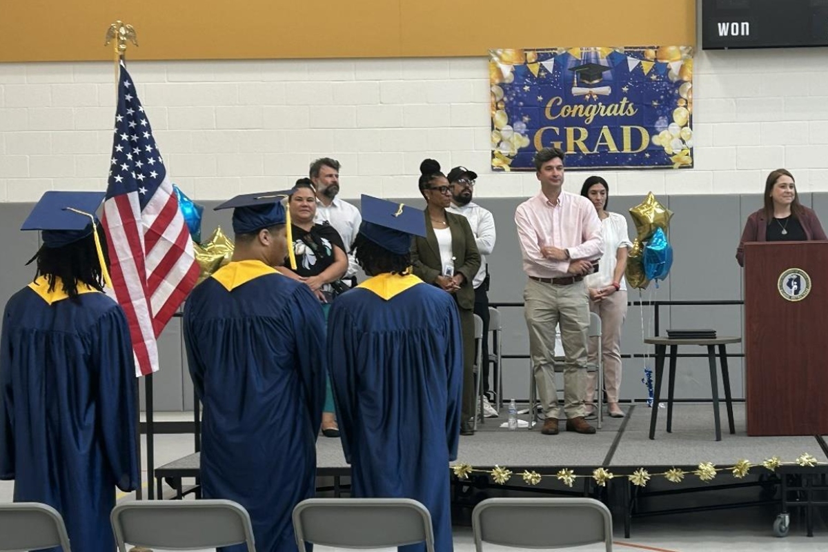 Traci Kinsley (at podium), principal of the high school at Monarch Youth Center, speaks to the graduates Monday, June 29.