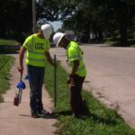 Workers with USIC identify areas for fiber optic lines while trying to beat the heat.