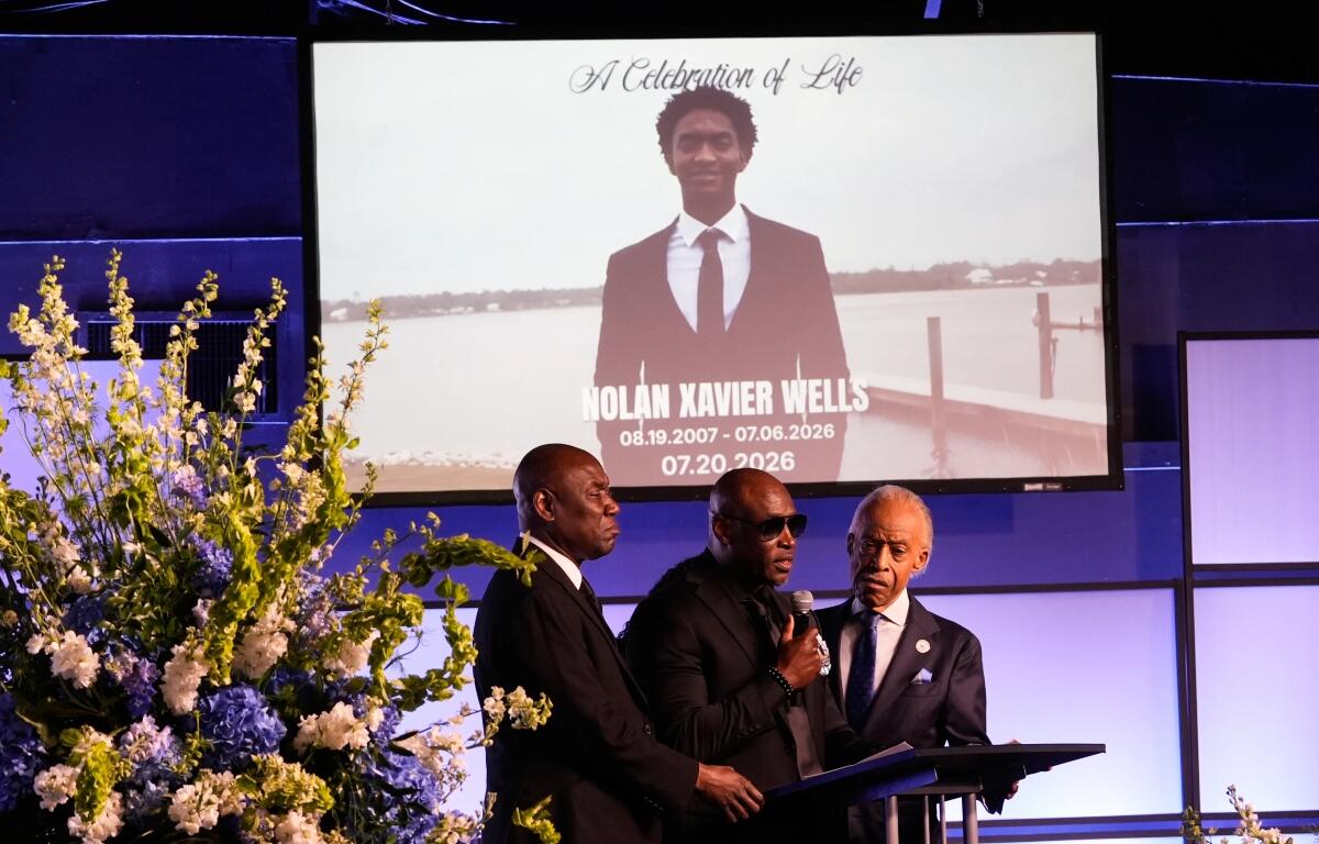 Elmore Wonsley, center, speaks next to attorney Ben Crump, left, and Rev. Al Sharpton during a memorial service for Nolan Xavier Wells, an 18-year-old found dead after taking a July 4 boat trip with friends, Monday, July 20, 2026, in Ocean Springs, Miss. (AP Photo/Gerald Herbert)