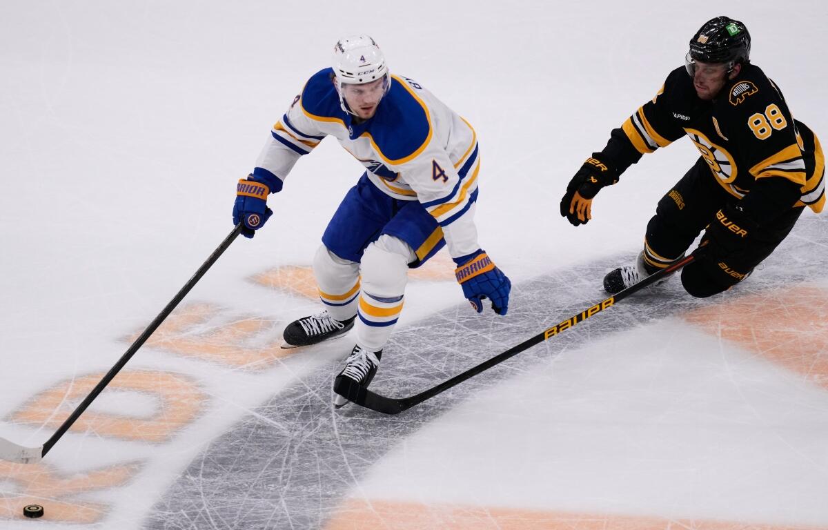 FILE - Buffalo Sabres defenseman Bowen Byram (4) controls the puck against Boston Bruins right wing David Pastrnak (88) during Game 3 of a first-round NHL hockey Stanley Cup playoff series, April 23, 2026, in Boston. (AP Photo/Charles Krupa, File)