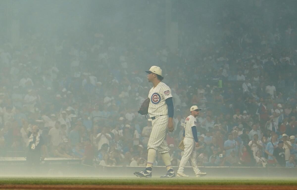 Chicago Cubs pitcher Shota Imanaga stands amidst smoke after fireworks before a baseball game against the St. Louis Cardinals, Saturday, July 4, 2026, in Chicago. (AP Photo/David Banks)