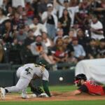 Chicago White Sox's Tristan Peters, right, slides safely into third base for an RBI triple while Athletics third baseman Joshua Kuroda-Grauer, center, catches the throw during the seventh inning of a baseball game in Chicago, Friday, July 10, 2026. (AP Photo/Paul Beaty)
