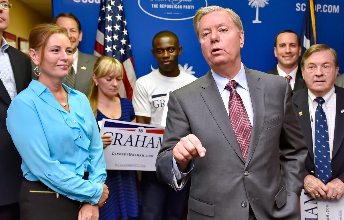 FILE - Republican presidential candidate, Sen. Lindsey Graham, R-S.C., accompanied by his sister Darline, left, speaks at the GOP headquarters in Columbia, S.C., Sept. 1, 2015, where he filed for the South Carolina Presidential Primary. (AP Photo/Richard Shiro, File)