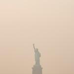The Statue of Liberty is photographed from the Staten Island Ferry as smoke from wildfires blankets the sky, Thursday, July 16, 2026, in New York. (AP Photo/Yuki Iwamura)