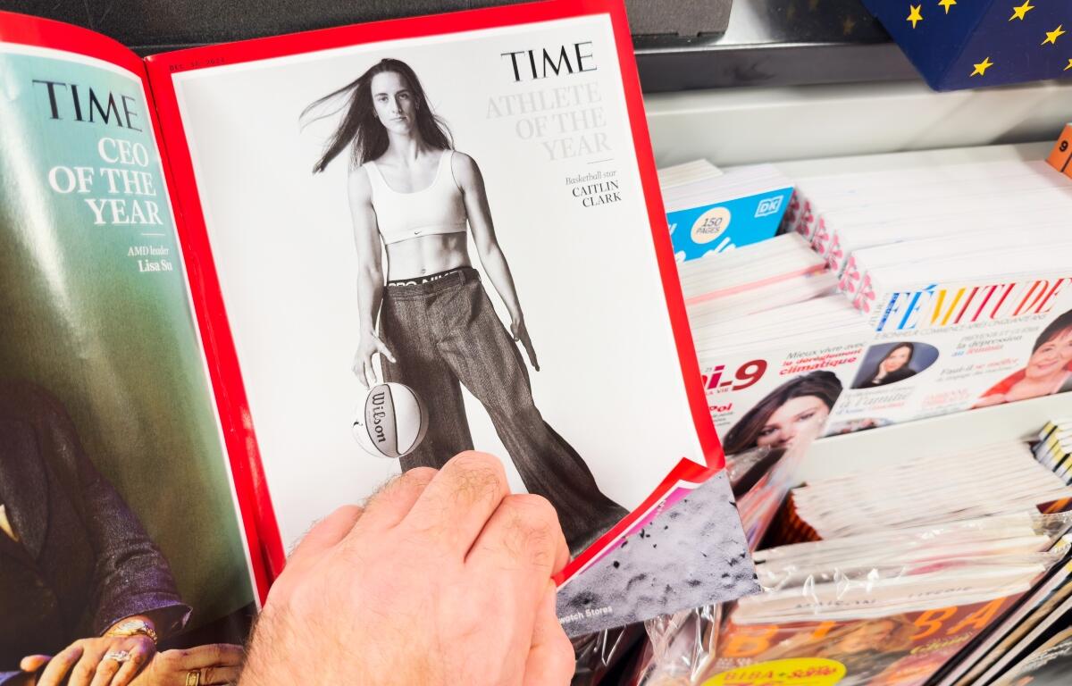 Paris, France - Dec 28, 2024: A person flipping through Time magazine, featuring Caitlin Clark as Athlete of the Year with a basketball, alongside the CEO of the Year page.