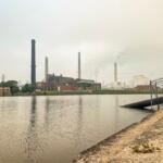 Power station smoke stack chimney billows smoke into the air. Smoke from Canadian wildfires hangs heavy in the sky creating dangerous air quality conditions. Located in Central Illinois, USA.
