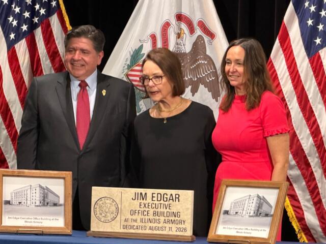Governor JB Pritzker, widow Brenda Edgar, and daughter Elizabeth, pose in front of plaques and a hand-made sign to be placed at the Illinois Armory, now the Jim Edgar Executive Office Building.