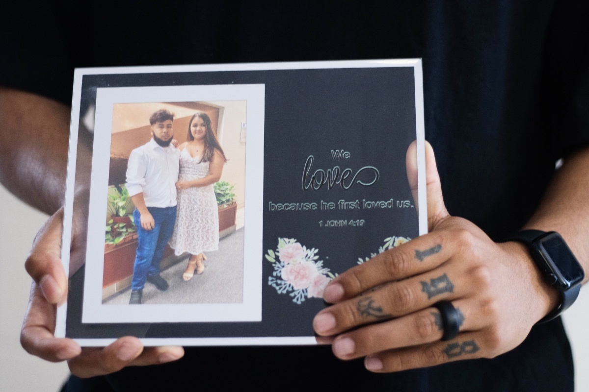 Army Sgt. Hedar Leonel Turcios Juarez holds a picture of himself with with his wife Cristy, who is currently on immigration detention, at home in El Paso, Texas, July 21, 2026. (AP Photo/Ryan Romero)
