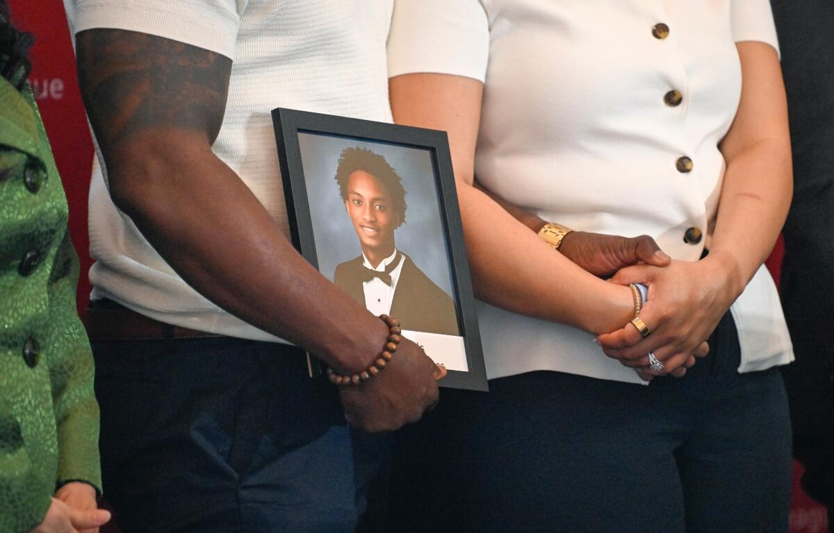 Christine Wonsley and Elmore Wonsley, mother and step father of Nolan Wells, stand on a stage with a photo of their son as they appear at the National Urban League's annual conference to share updates on his death, as well as Daniel Erving, and Tyler Smith, Thursday, July 30, 2026, in Nashville, Tenn. (AP Photo/John Amis)