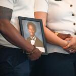 Christine Wonsley and Elmore Wonsley, mother and step father of Nolan Wells, stand on a stage with a photo of their son as they appear at the National Urban League's annual conference to share updates on his death, as well as Daniel Erving, and Tyler Smith, Thursday, July 30, 2026, in Nashville, Tenn. (AP Photo/John Amis)