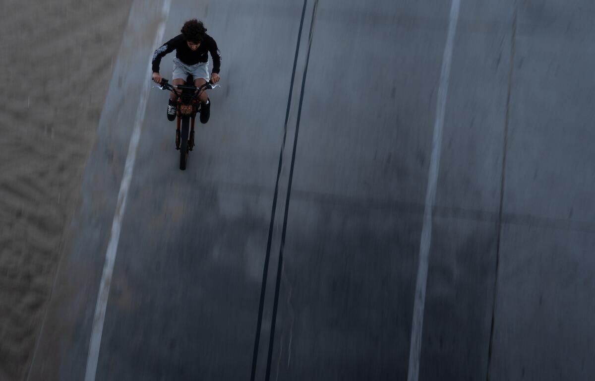 A boy rides an e-bike in Santa Monica, Calif., Monday, Aug. 10, 2026. (AP Photo/Jae C. Hong)