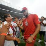 St. Louis Cardinals' Joshua Baez, right, celebrates with his mother Yris Carmen Baez, left, after defeating the Chicago Cubs in a baseball game in Chicago, Saturday, Aug. 15, 2026. (AP Photo/Paul Beaty)