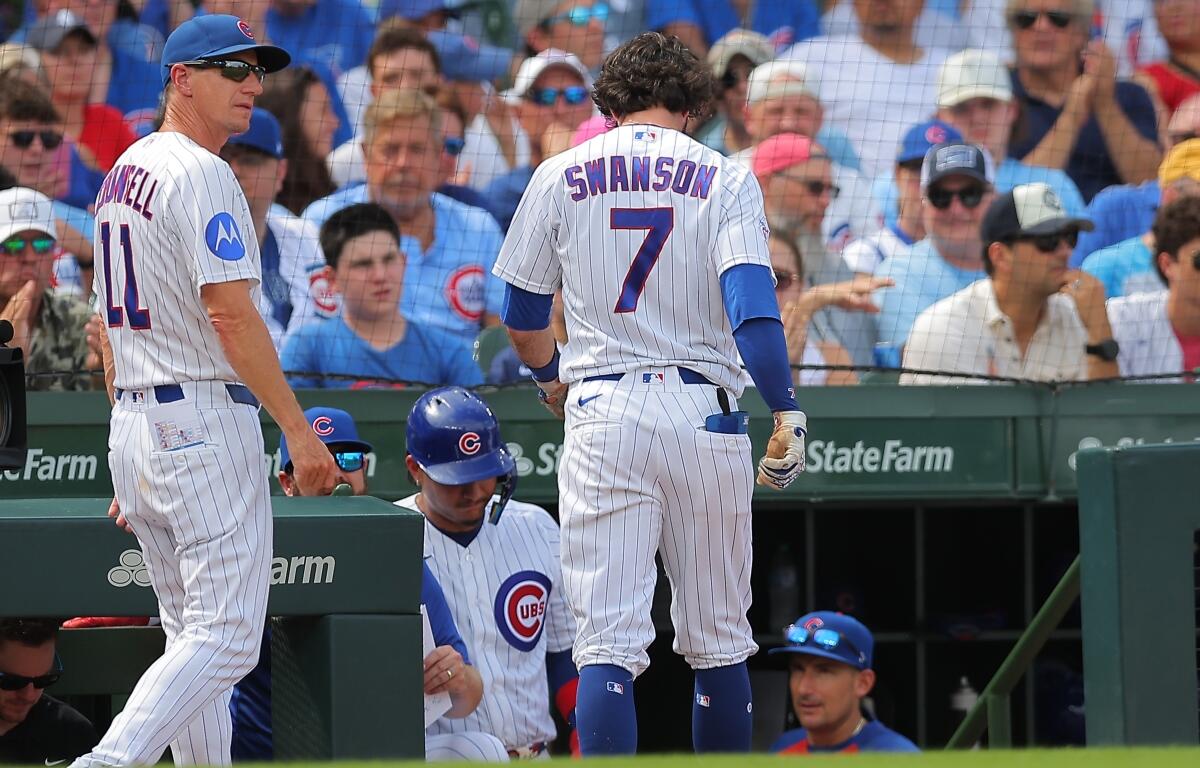 Chicago Cubs manager Craig Counsell, left, walks back to the dugout with Dansby Swanson (7) during the third inning of a baseball game against the St. Louis Cardinals, Sunday, Aug. 16, 2026, in Chicago. (AP Photo/Melissa Tamez)