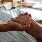 nurse holding a hand of a patient