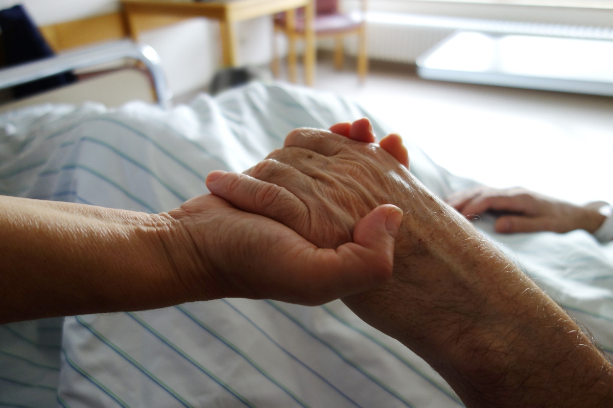 nurse holding a hand of a patient