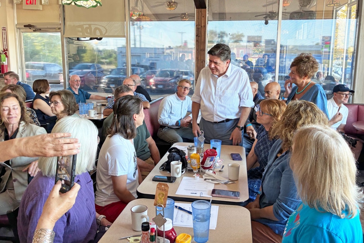 Gov. JB Pritzker speaks with Emily Waugh of Oregon at Lulu’s Diner in Springfield on Thursday, Aug. 27, 2026. (Capitol News Illinois photo by Ben Szalinski)