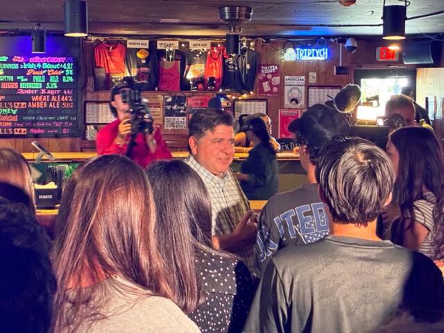 Gov. JB Pritzker speaks with University of Illinois student Rami Khosho at Rose Bowl Tavern in Urbana on Thursday, Aug. 27, 2026. (Capitol News Illinois photo by Ben Szalinski)