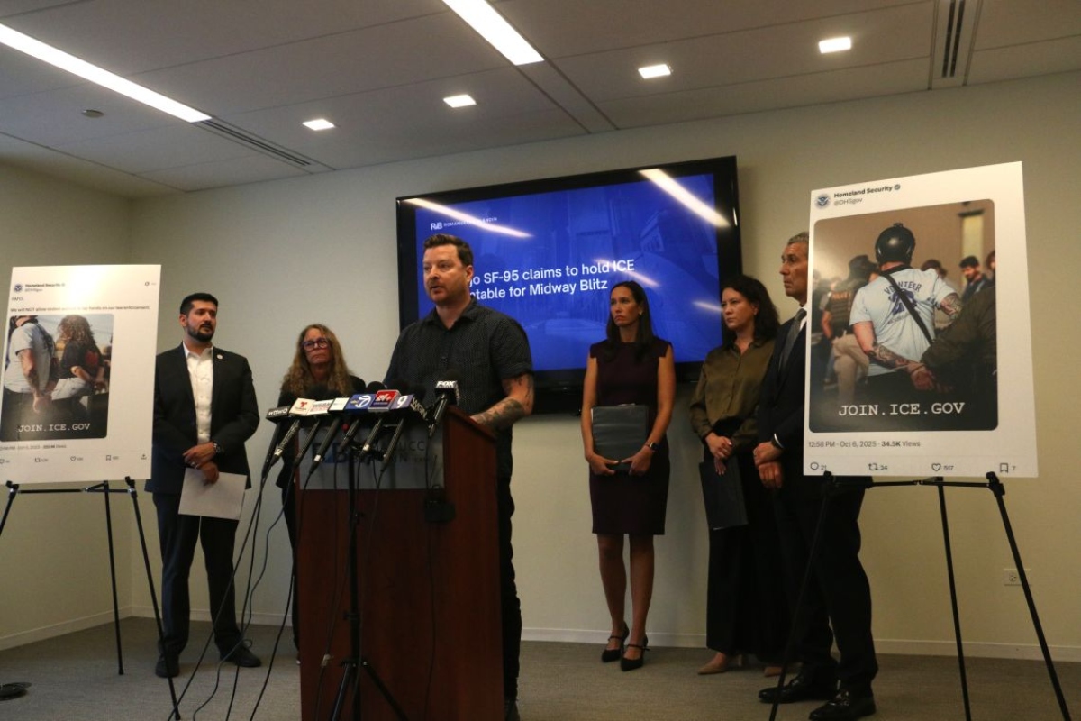 Harvard data scientist Kyle Frankovich stands at a Sept. 17, 2026, news conference between photos of Department of Homeland Security social media posts using images of him with his arms zip-tied behind his back after protesting at the Broadview immigration detention center. (Capitol News Illinois photo by Maggie Dougherty