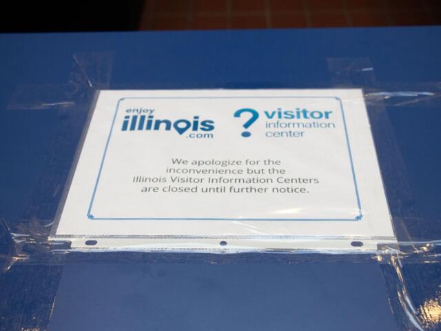 A visitor information desk at the Prairie View Rest Area announces the closure of the visitor information centers “until further notice” on Sept. 21, 2026. Nearby shelves for brochures and tourism magazines were empty. (Capitol News Illinois photo by Maggie Dougherty)