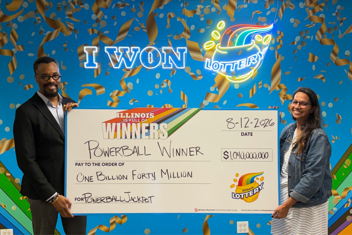 Illinois Lottery Director, Harold Mays (left), and Chicago Prize Center manager Amanda Crosas hold the big check representing the $1.04 billion Powerball jackpot from the August 12 drawing.