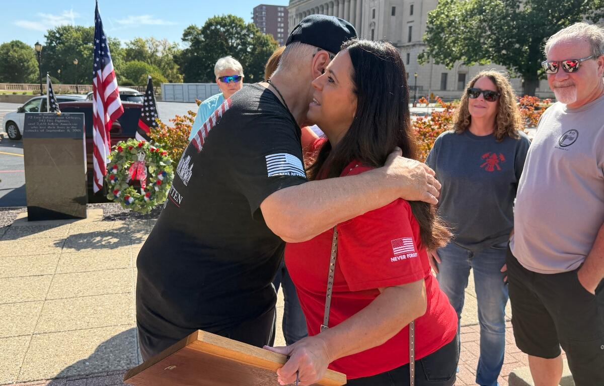 Ross Horne, Ride to Remember organizers, share an embrace with Springfield Mayor Misty Buscher, after she received a special appreciation plaque from the Springfield Salvation Army.