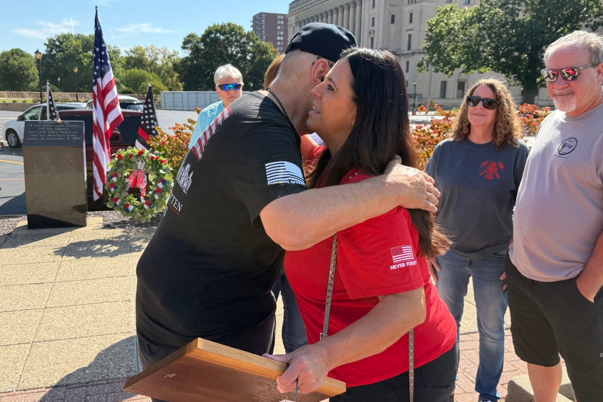 Ross Horne, Ride to Remember organizers, share an embrace with Springfield Mayor Misty Buscher, after she received a special appreciation plaque from the Springfield Salvation Army.