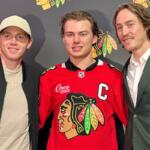 In this photo taken with a smartphone, Chicago Blackhawks players, from left, Patrick Kane, Connor Bedard and Tyler Bertuzzi pose during a news conference introducing Bedard as the new captain of the NHL hockey club, Tuesday, Sept. 15, 2026, in Chicago. (AP Photo/Jay Cohen)