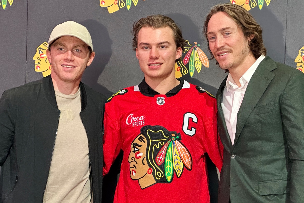 In this photo taken with a smartphone, Chicago Blackhawks players, from left, Patrick Kane, Connor Bedard and Tyler Bertuzzi pose during a news conference introducing Bedard as the new captain of the NHL hockey club, Tuesday, Sept. 15, 2026, in Chicago. (AP Photo/Jay Cohen)