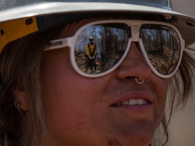 Women-in-Fire fellow Piper Morris looks on at Izaiah Lees while the two, both with The Nature Conservancy, wait for a unit to burn March 25, 2026, in Makanda, Illinois. (Lylee Gibbs for the Saluki Local Reporting Lab)