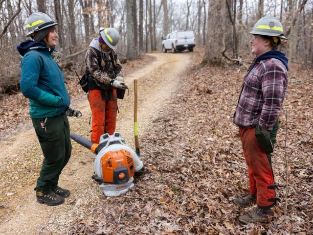Left: Pen Johnson, Piper Morris and Danielle Cafin stand together as they take a break from preparing a burn unit March 16, 2026, at Trail of Tears State Forest in Jonesboro, Illinois. Right: Fire burns through a burn unit near Giant City Lodge as The Nature Conservancy’s Illinois Chapter burns along with IDNR and other organizations March 25, 2026, in Makanda, Illinois. (Lylee Gibbs for the Saluki Local Reporting Lab)