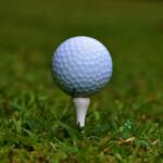 Golf ball on white tee detail closeup golfing