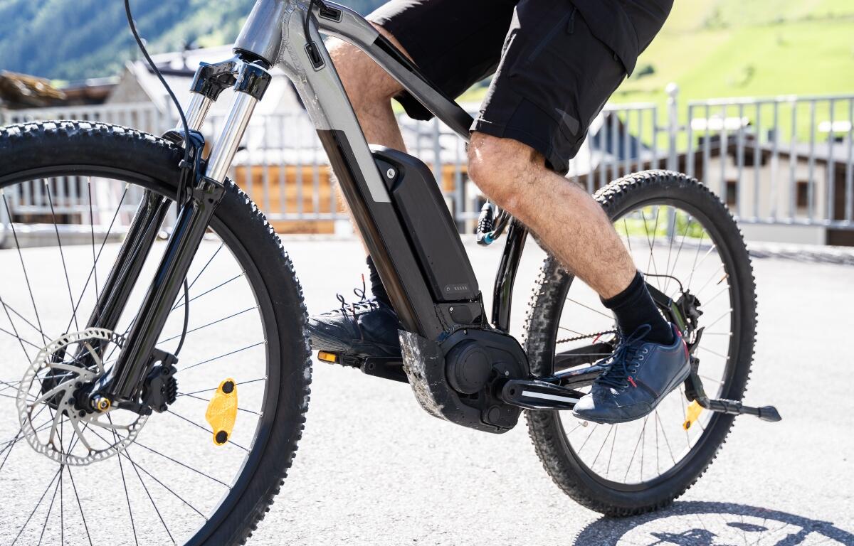 Man Riding E Bike Bicycle In City. Electric Bike In Summer
