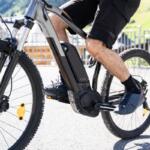 Man Riding E Bike Bicycle In City. Electric Bike In Summer