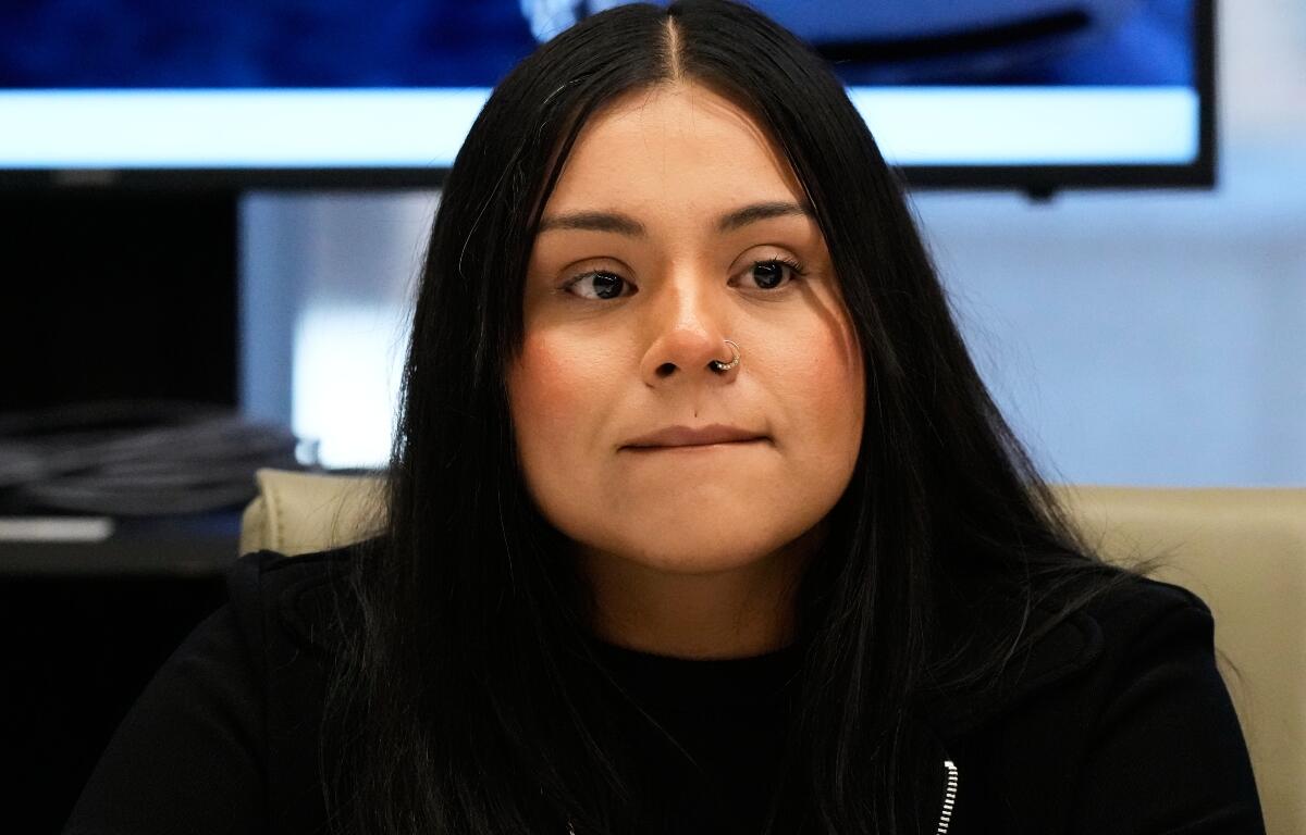 Marimar Martinez, a Chicago woman who was shot by a Border Patrol agent last year, listens to attorney Christopher Parente at a press conference Monday, Oct. 5, 2026, in Chicago. (AP Photo/Nam Y. Huh)
