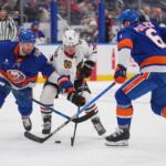 New York Islanders' Adam Pelech (3) and Ryan Pulock (6) fights for control of the puck with Chicago Blackhawks' Frank Nazar (91) during the first period of an NHL hockey game Thursday, Oct. 8, 2026, in Elmont, N.Y. (AP Photo/Frank Franklin II)