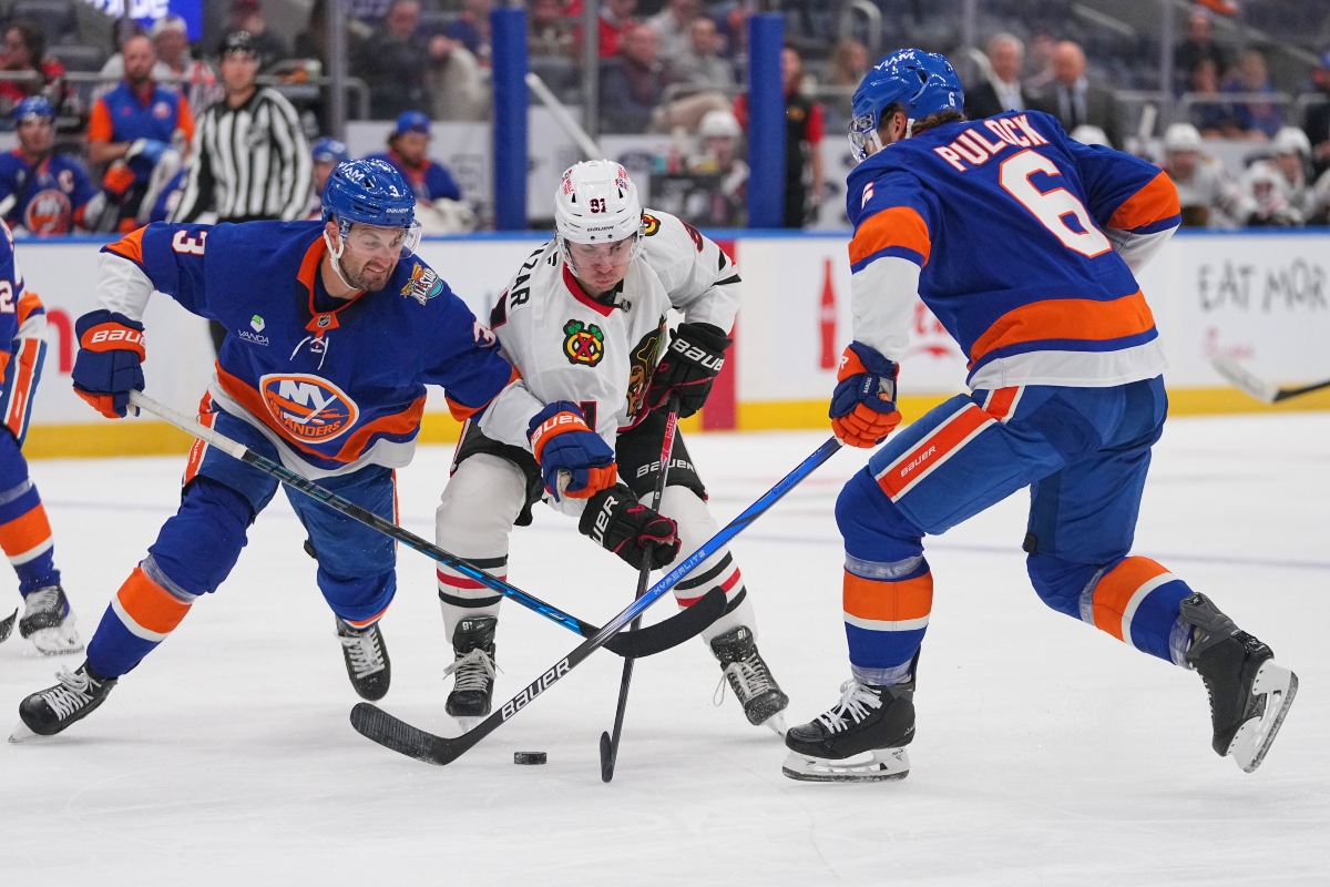 New York Islanders' Adam Pelech (3) and Ryan Pulock (6) fights for control of the puck with Chicago Blackhawks' Frank Nazar (91) during the first period of an NHL hockey game Thursday, Oct. 8, 2026, in Elmont, N.Y. (AP Photo/Frank Franklin II)